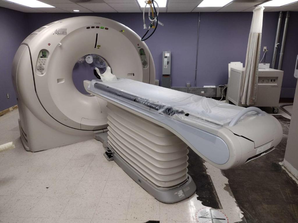 Toshiba Aquilion CT scanner with patient table in a clinical imaging room